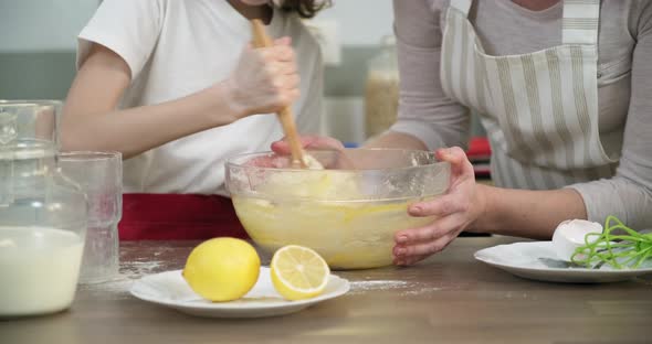 Mother and Daughter Child Together at Home Kitchen Kneading Dough in Bowl, Close-up