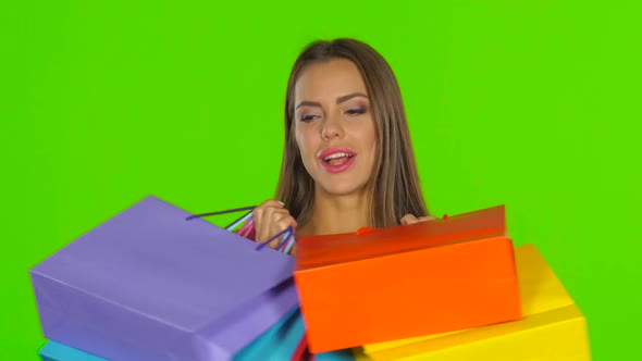 Woman Holding Shopping Bags and Smiling, Green Screen