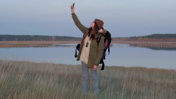 Young Woman in the Forest Trying to Catch a Mobile Signal