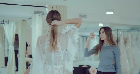 Girl Wore a Wedding Dress and Does a Fitting in Front of a Mirror