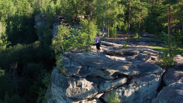 Aerial View of a Girl Doing Fitness and Yoga on the Edge of a Cliff