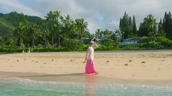 Aerial Slow Motion Woman in Dress Flattering on Breeze Walking By Sandy Beach