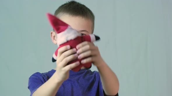 Portrait of a Child Boy Playing with a Small Santa Clause Toy