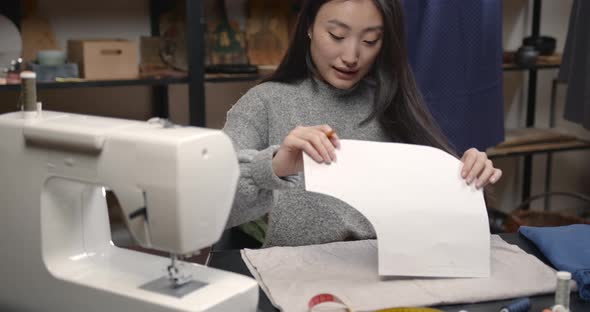Professional Young Female Tailor Working in Workshop
