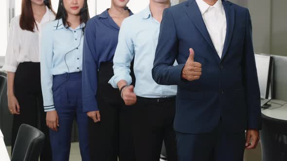 Business team showing thumbs up sign gesture and looking at camera