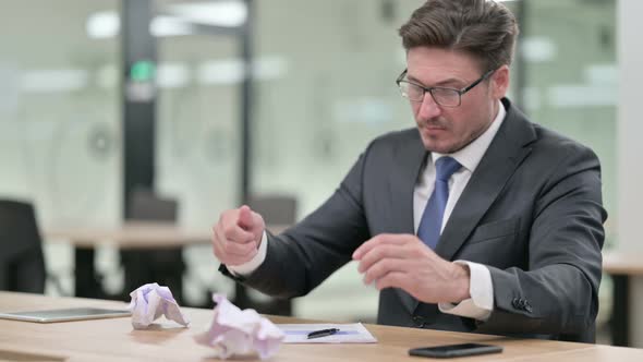 Middle Aged Businessman Having Failure Writing on Paper in Office 