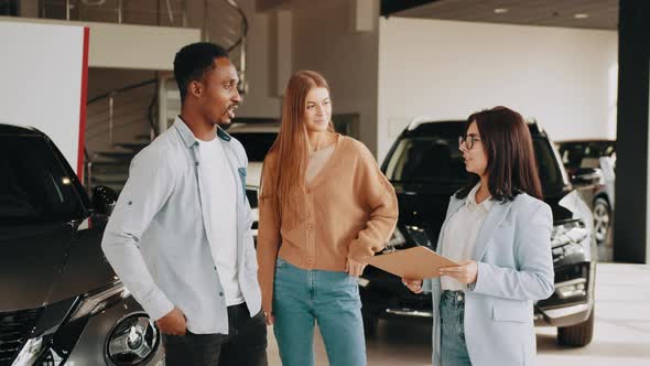 Multi Ethnic Couple Visiting Auto Salon for Choosing New Car