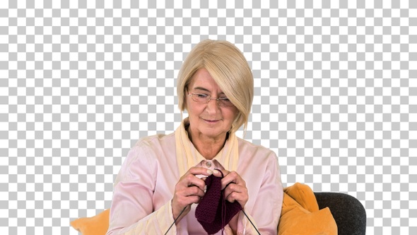 Senior lady knitting sitting on a chair, Alpha Channel