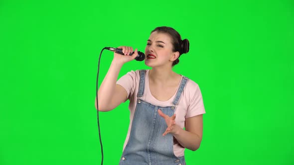 Cheerful Girl Sings Into a Microphone and Moves To the Beat of Music