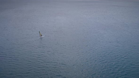Aerial view of man doing windsurfing at the sea in Greece.