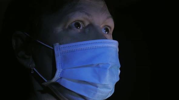 The Lady Wearing the Face Mask Inside the Dark Room