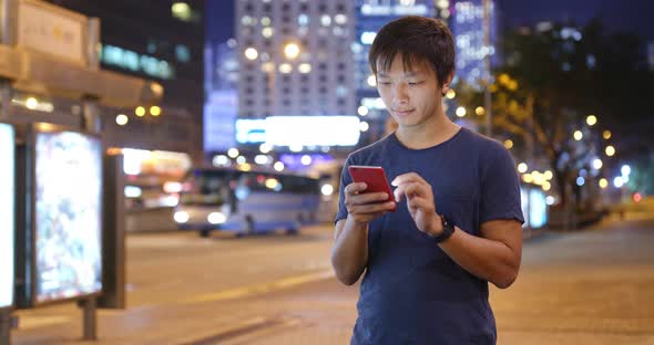 Asian Man use of mobile phone in city of Hong Kong at night