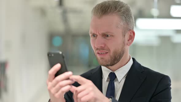 Portrait of Upset Businessman Having Loss on Smartphone 