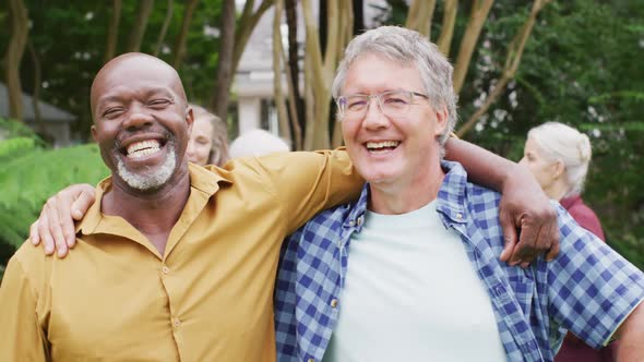 Animation of happy diverse male senior friends embracing in garden