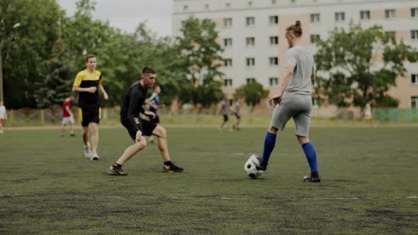 Football Team Players Practice on a Soccer Field in a Residential Area of the City and Practice Game