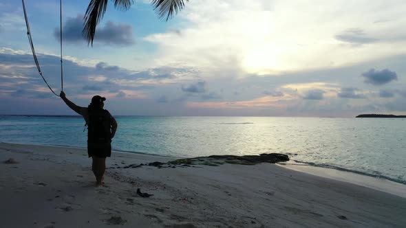 Tourist sunbathes on perfect seashore beach adventure by blue green lagoon and clean sandy backgroun