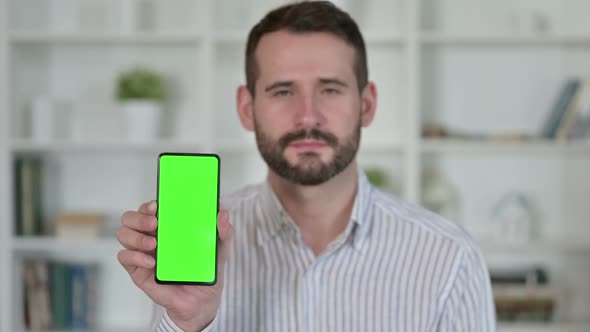 Portrait of Young Man Holding Smartphone with Chroma Screen