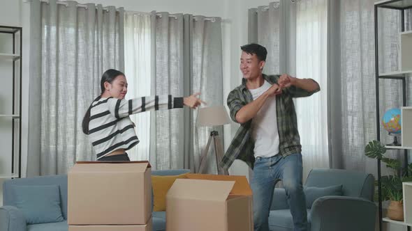 Happy Young Asian Couple Celebrating Finish Carrying Cardboard Boxes With Stuff Into A New House