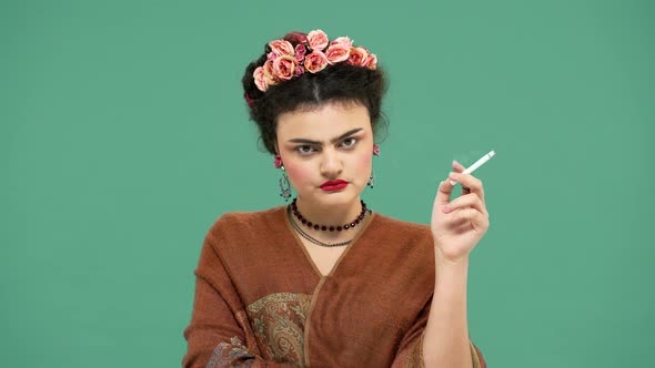 Portrait of Woman Frida Kahlo Lookalike Wearing Handmade Accessories Looking Seriously and Shaking