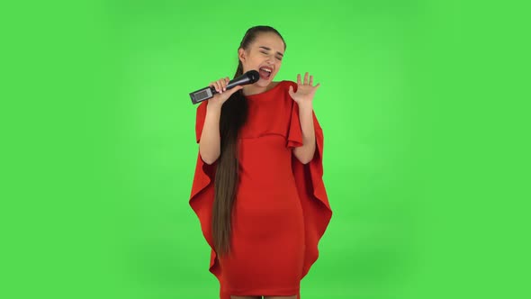 Pretty Young Woman Is Singing Into a Microphone and Moving To the Beat of Music. Green Screen