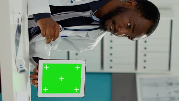 Vertical Video Male Doctor Showing Tablet with Greenscreen on Display