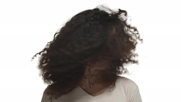 Closeup of Happy Darkskinned Woman with Long Curly Hairstyle Whiping Hair and Laughing Advertising