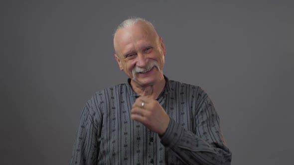 Funny Grey Haired Grandfather in Dark Shirt Makes Comic Face