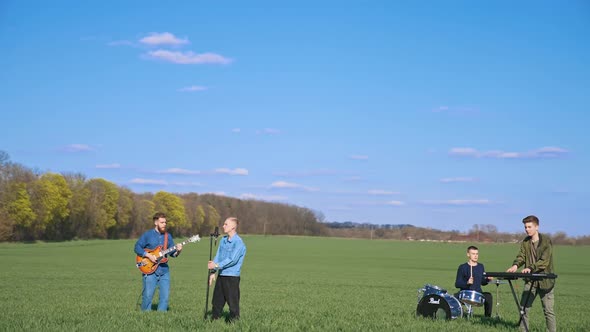 Young musical band having concert on field