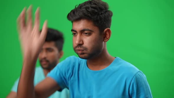 Stressed Football Fan Gesturing Holding Head in Hands Looking Back at Blurred Friend with German