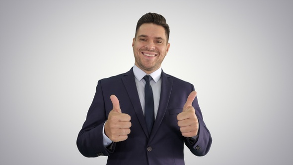 Happy business man holding thumbs up on gradient background.