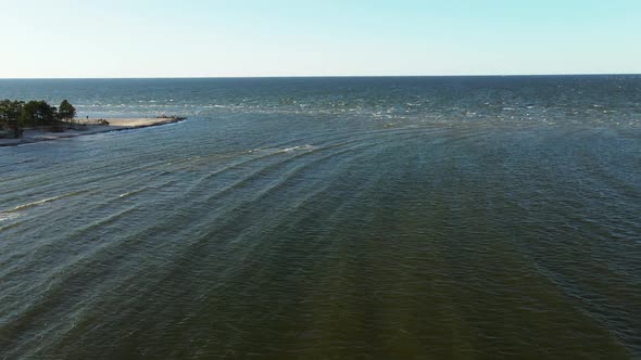 Aerial Flight Up: Drone Reveals Top Point of Cape Kolka Where Gulf Meets Sea with Tourists Taking