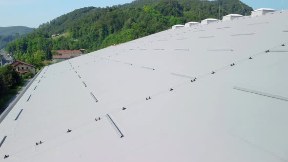 Big hall rooftop insulated with grey isolation panels with plastic light domes. Aerial 4k view.