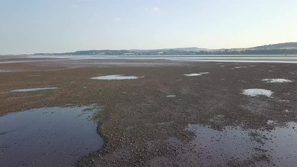 Lympstone harbour, England. Beautiful 4K aerial footage at low tide, countryside background.