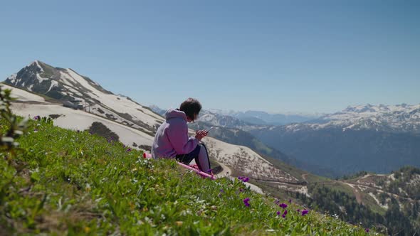 Hiker Woman is Viewing Pictures in Smartphone Resting at Top of Mount