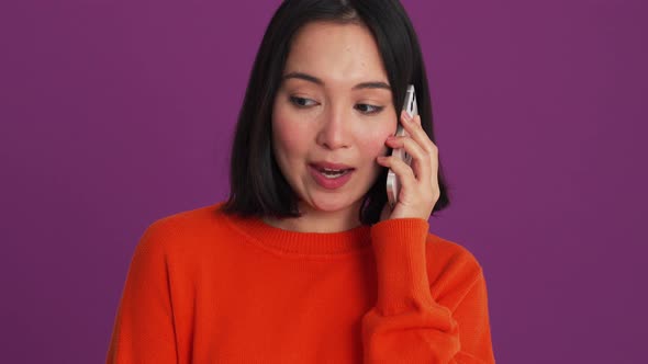 Laughing woman in red sweater talking on phone