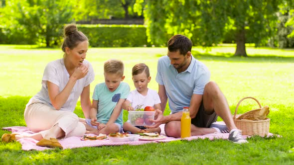 Happy Family Eating Fruits on Picnic at Park