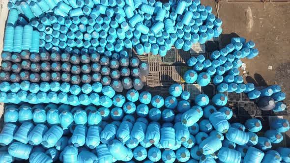 Aerial Up and Down View of Blue and Black Plastics Barrels Tanks Open-air Warehouse