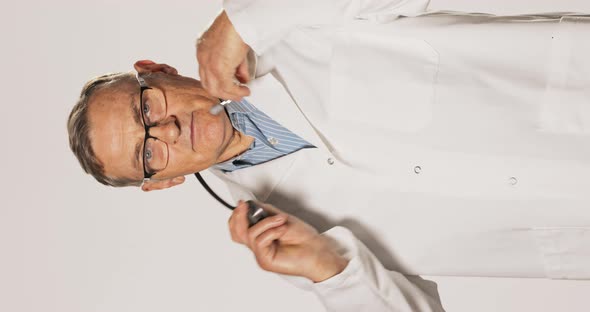 Mature Professional Experienced Pediatric Specialist Dressed in a Shirt White Apron and Glasses Puts