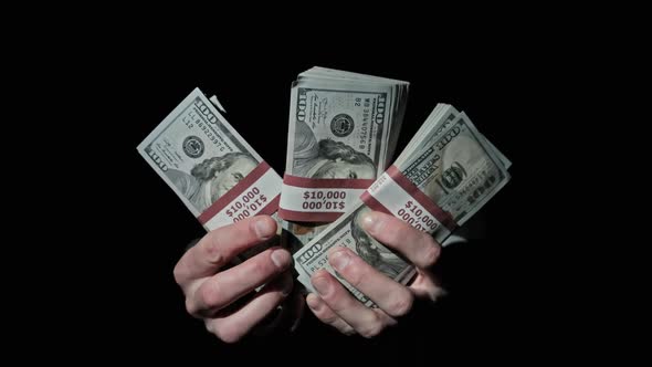 Three Stacks of 10000 American Dollars Bundles in Male Hands on Black Background