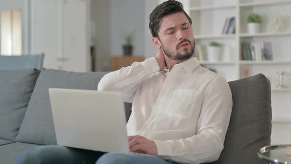 Hardworking Man with Laptop Having Neck Pain at Home