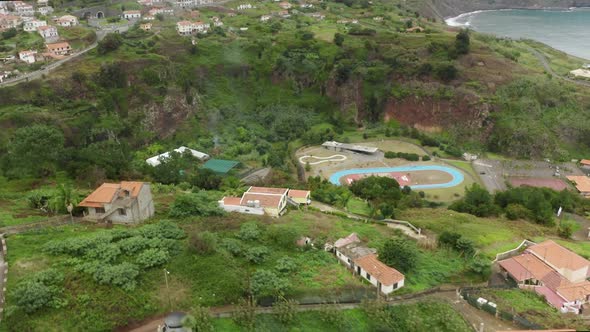 Aerial Footage of High Volcanic Hillsides with Coastal Cottages on Top