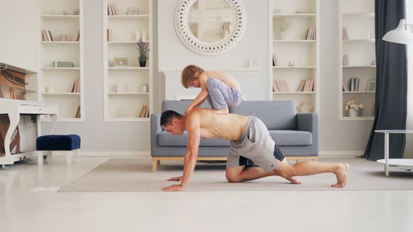 Sport Time at Home in the Living Room Dad with His Small Cute Son Doing Pushups Together While the