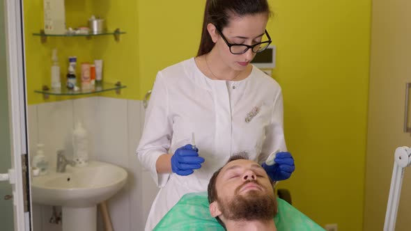 Cosmetologist Preparing Man for Hair Mesotherapy Procedure in Beauty Clinic