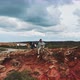 Drone shot of two men sitting on top of cliff with a dog - VideoHive Item for Sale