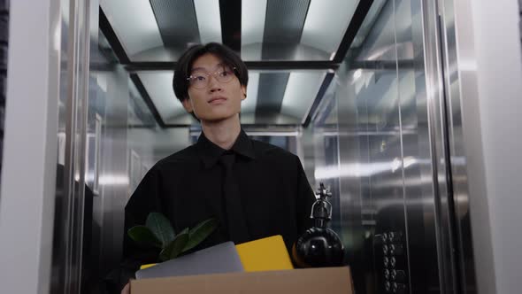 A Chinese Man Comes Out of the Elevator with a Box