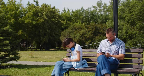 Father and Daughter Sits Buried in Smartphones After a Quarrel and Ignores Each Other