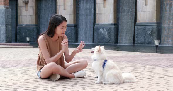 Woman playing with pomeranian dog at outdoot