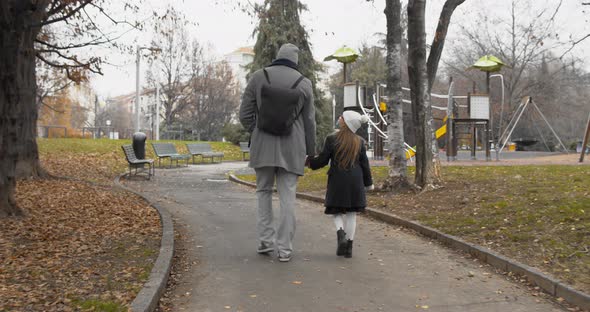 Back View of Father and His Girl Child Going To Park