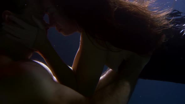 A Passionate and Beautiful Couple a Man and a Woman Swim Together Under the Water Move Beautifully