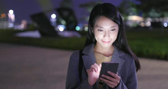 Young Woman use of mobile phone in Hong Kong at night